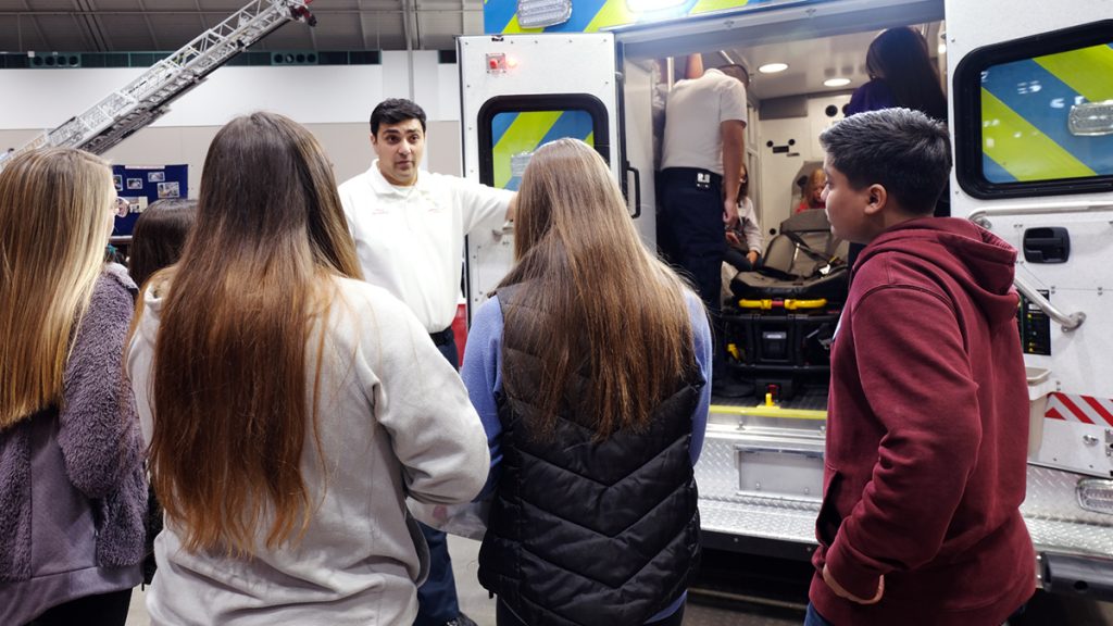 Students talking to a representative from the Olathe fire department at the Career Expo