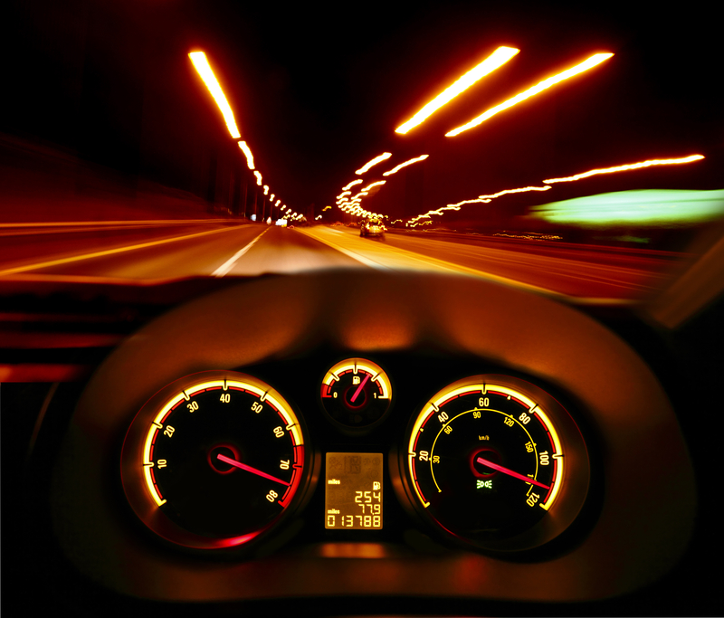 Car dashboard with blurred street lights through windshield