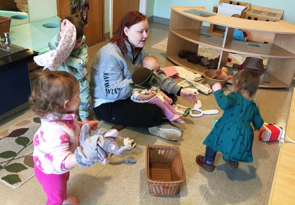 A teacher with dancing toddlers
