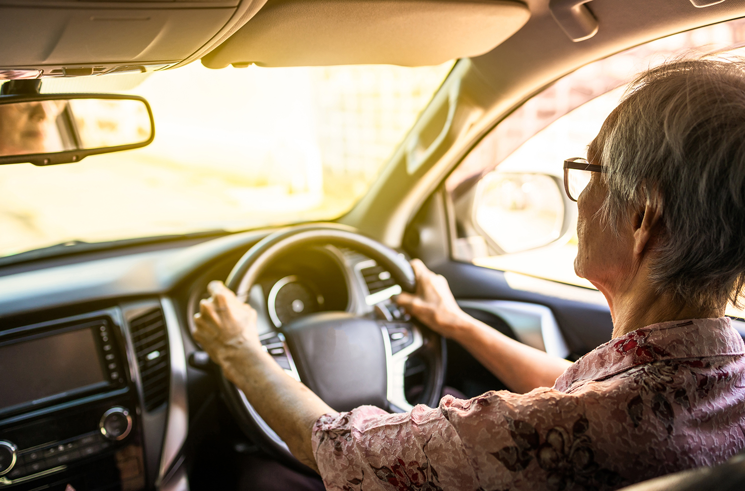 An older adult driving a car