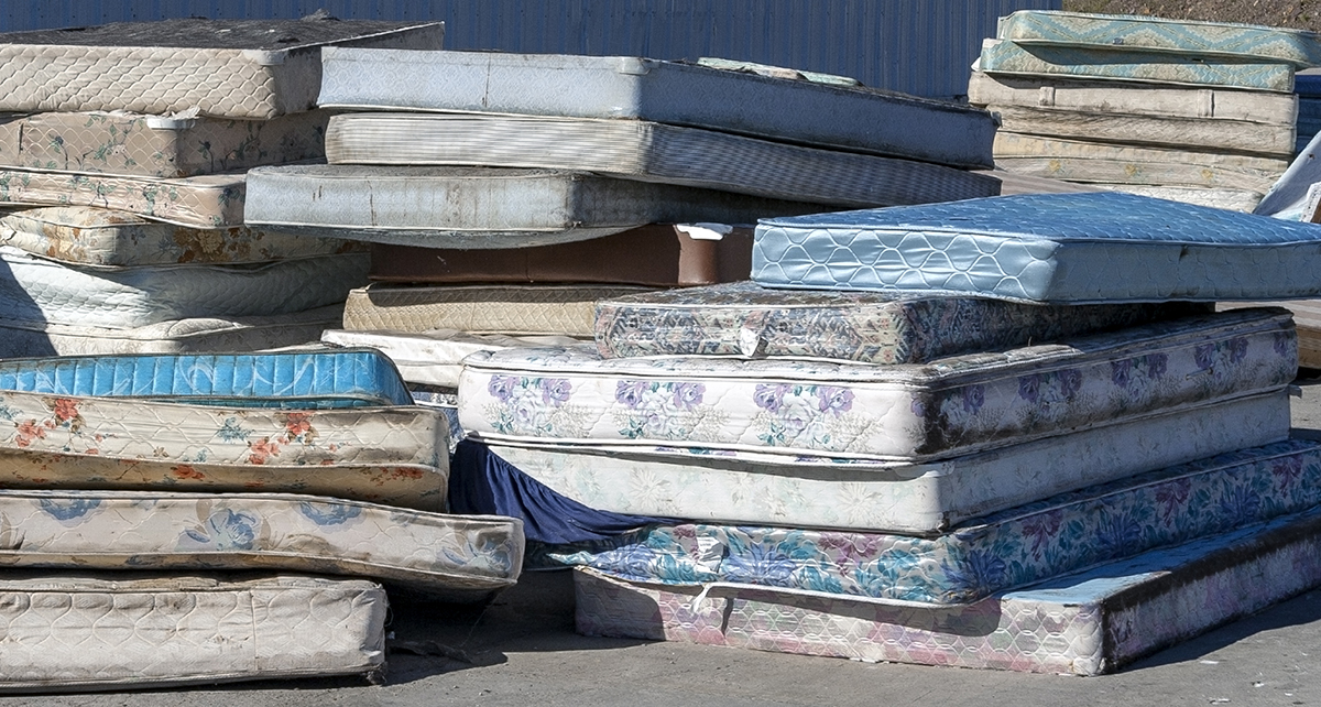 A pile of mattresses outside awaiting recycling