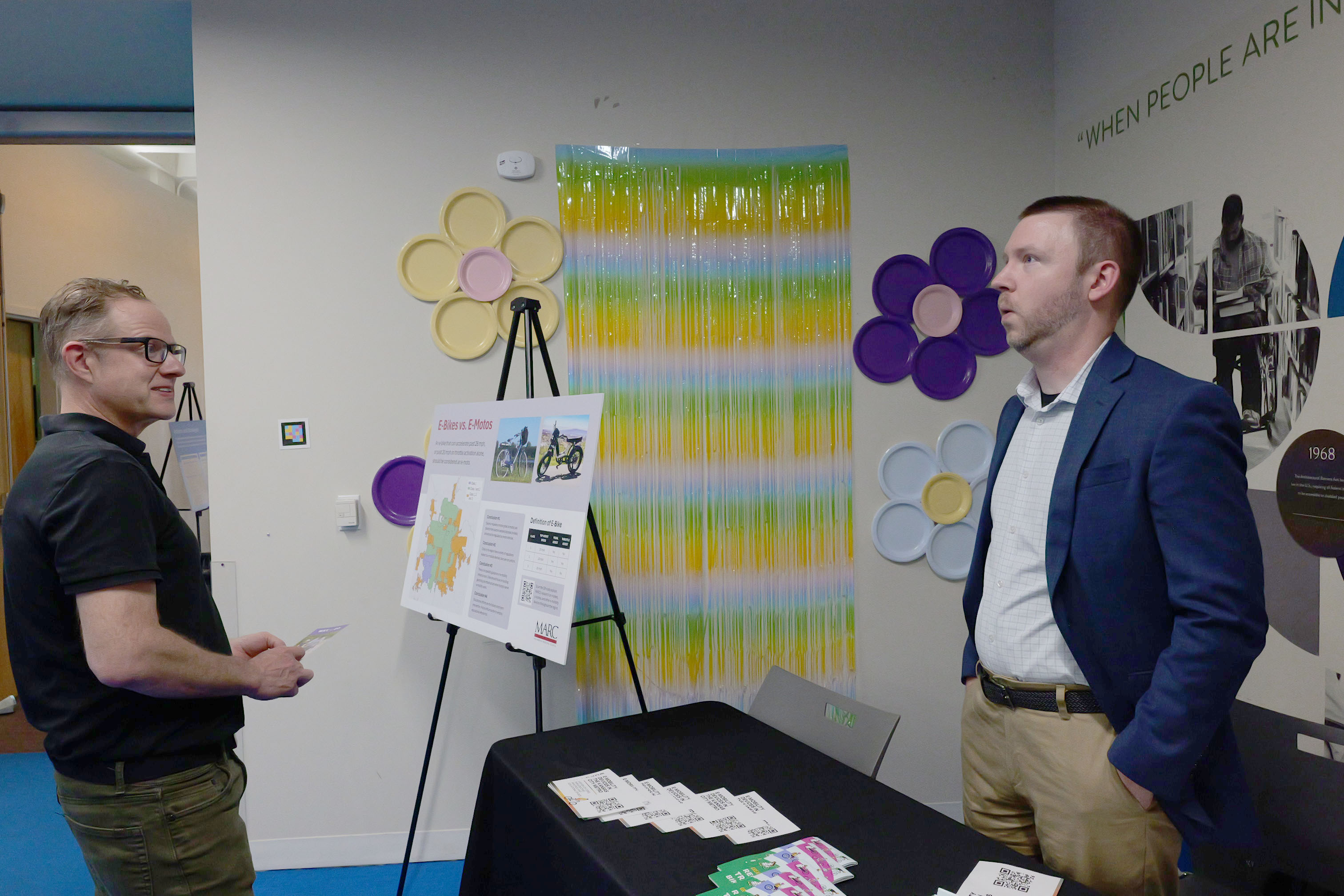 Group of people in a room sitting down listening to a presentation