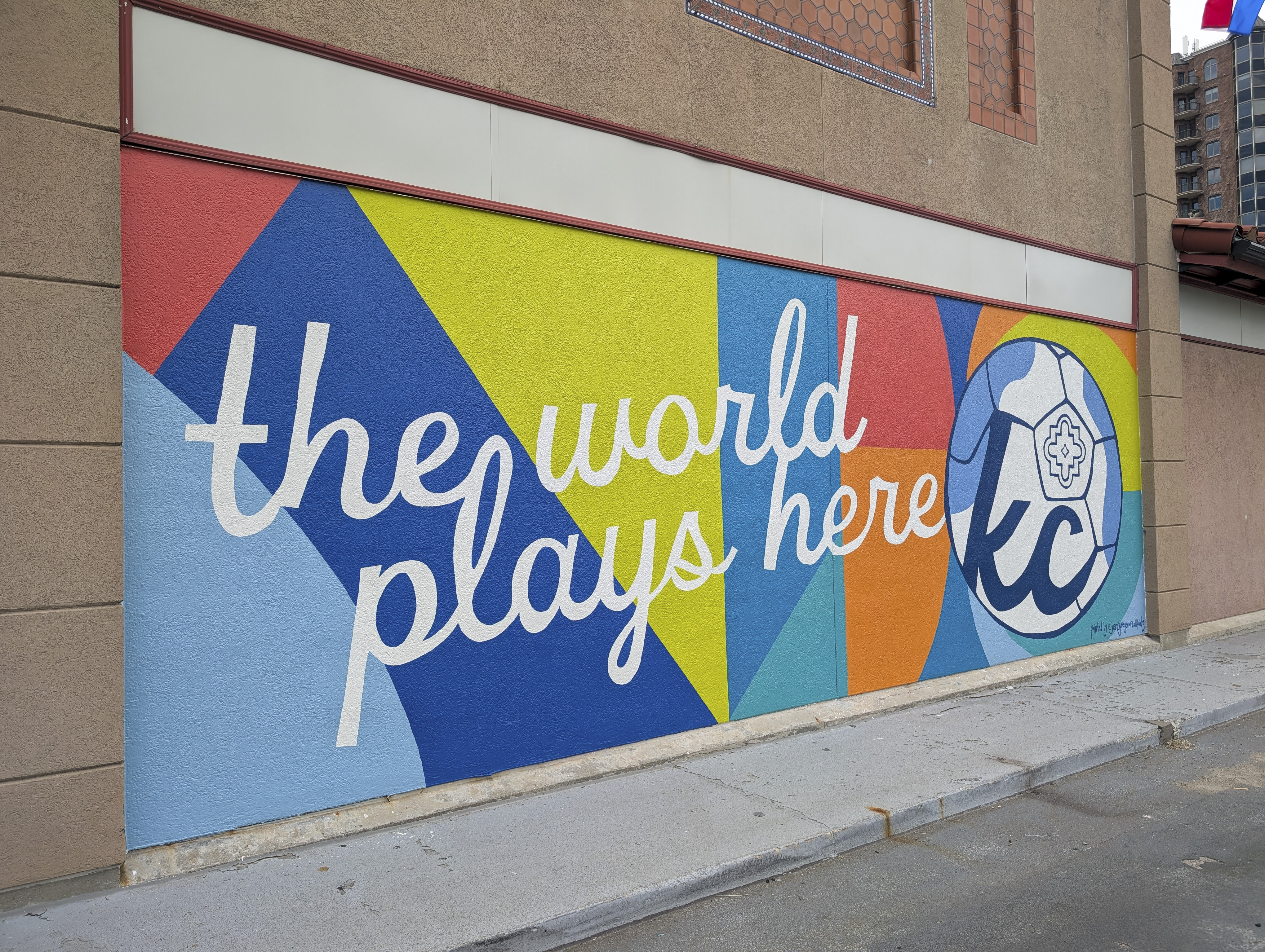 A colorful mural that reads "The World Plays Here" 