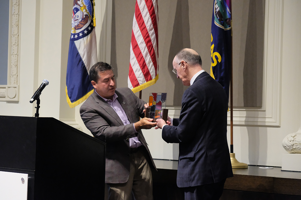 Mayor Beto Lopez presents a gift to David Warm