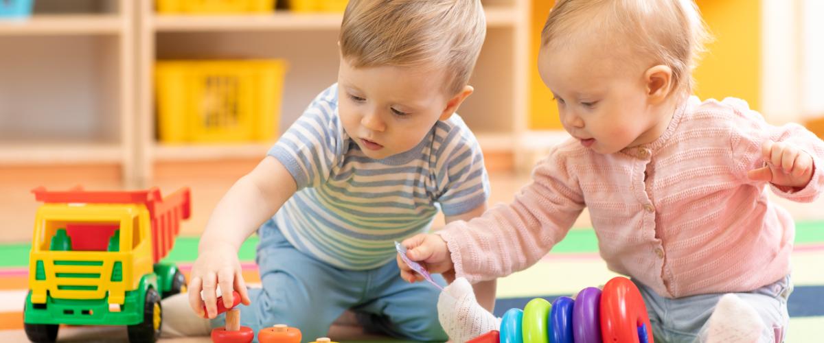 Two infants playing in a care center