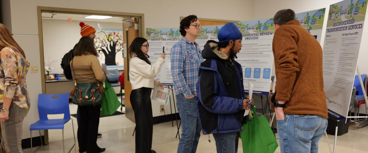 Public meeting with people looking at informational boards