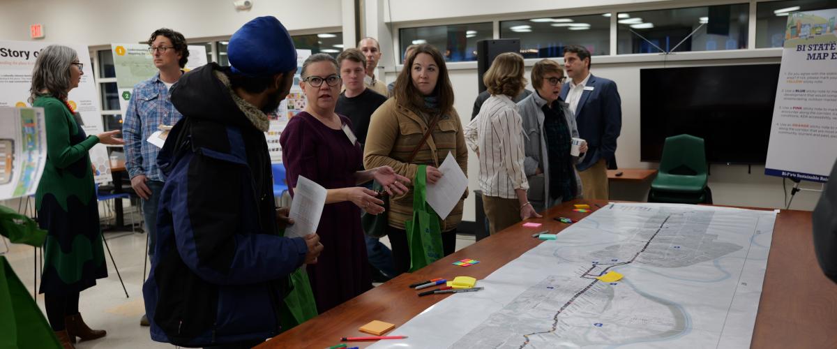 Public meeting with group of people in front of map on the table