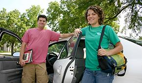 Two carpoolers standing next to car