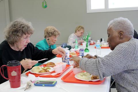 Older adults eating a meal at a senior center