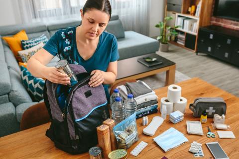 Person packing emergency supplies in a bag