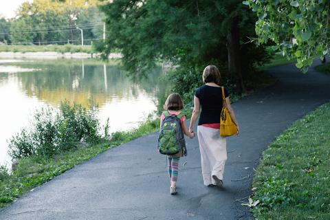 Woman and child walking on trail next to water
