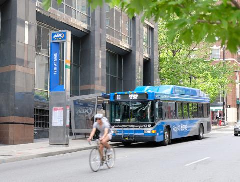 Bike rider on street with bus in background