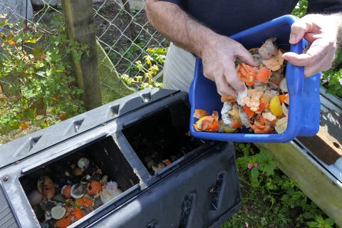 Food scraps being emptied into a compost container