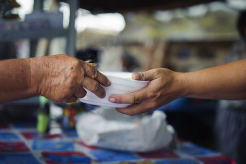 Two people exchanging a bowl