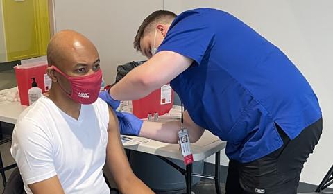 Man in a MARC mask receiving a vaccine
