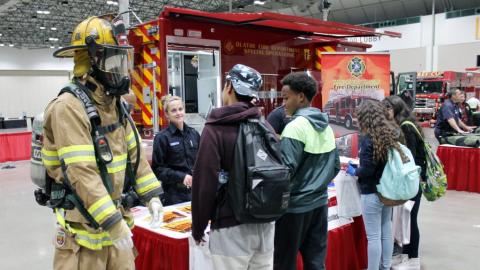 Students talking to a representative from the Olathe fire department at the Career Expo