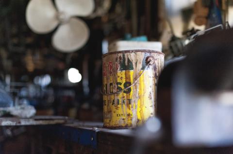 An old can of paint in a workshop