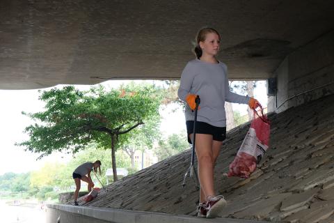Two people plogging under an overpass