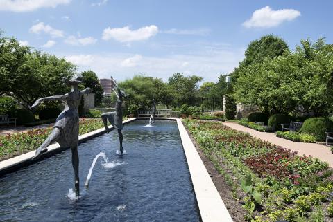 Statue of dancers skipping across water in fountain