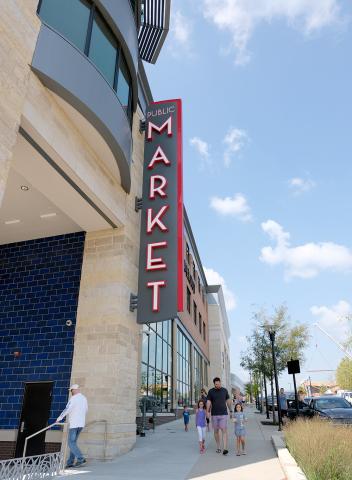 Lenexa Public Market sign with people walking on sidewalk