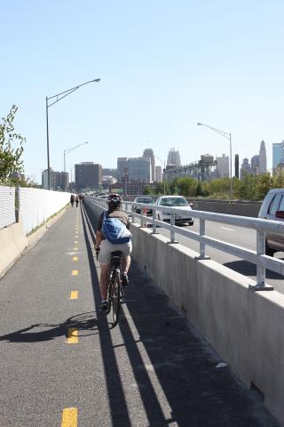 Bicyclist riding in bike lane on bridge with cars