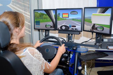 Woman using computer driving simulator