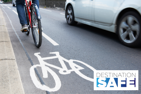 Bicyclist in bike lane riding next to car