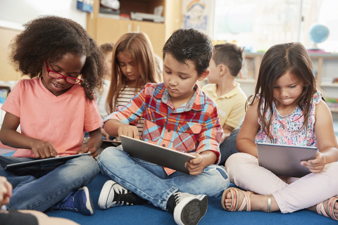 children learning in class using laptops