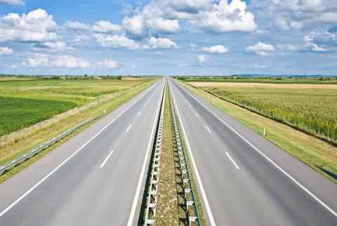 Two-lane open road with clouds in the sky