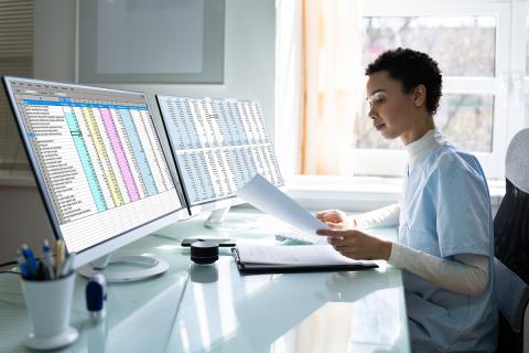 Person working at a computer with spreadsheets on the screens