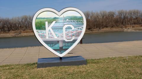 A Parade of Hearts sculpture sits near a sidewalk. 