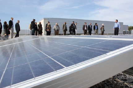 Visitors observing a demonstration of solar panels at work