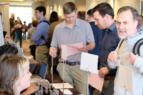 Attendees line up with pink carbon copy forms notatitng their professional development credit hours