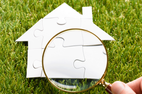 house puzzle pieces with magnifying glass image