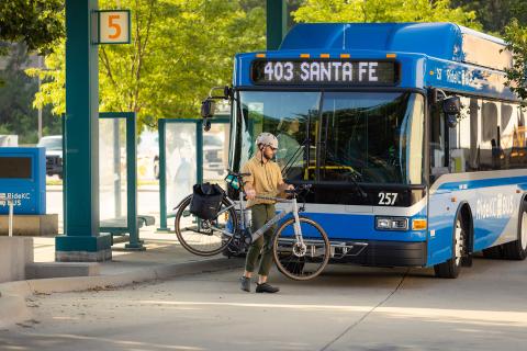 A man removing his bike from the front of a Ride KC bus