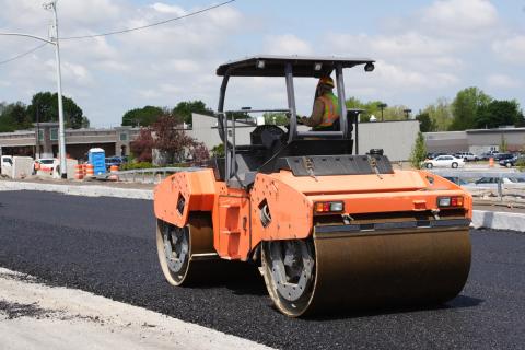 Asphalt steam roller resurfacing a road