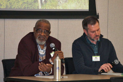 Speakers Richard Mabion and Jeff Severin sitting at a panel table with microphones