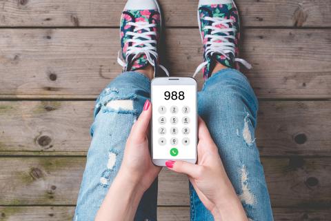 Young person calling 988 on a mobile phone