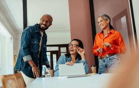 Three people at a table looking happy