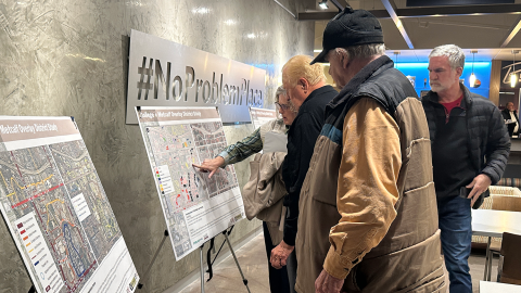 Citizens look over maps and diagrams for the OP Central plan