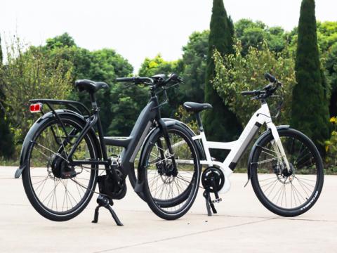 Two e-bikes on kickstands outside