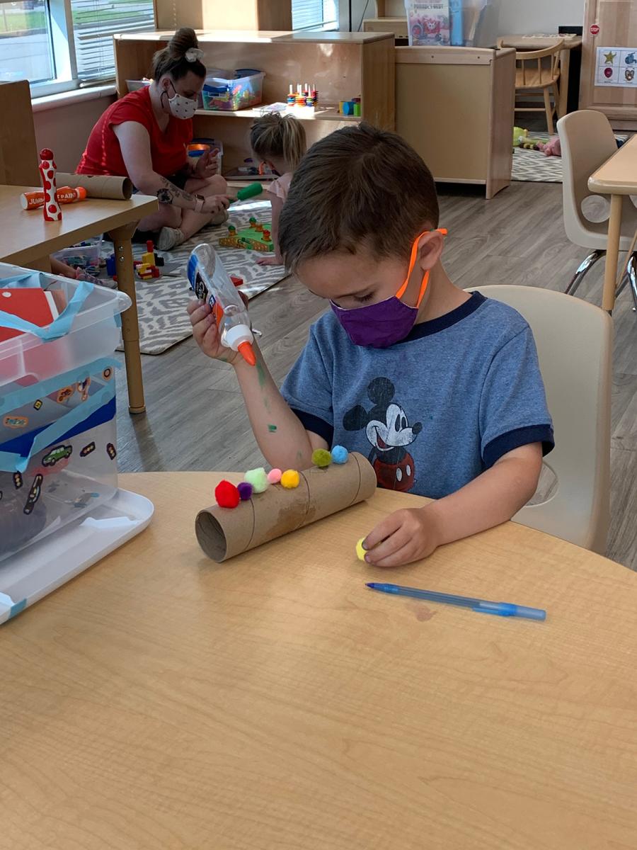 Boy wearing a face mask creating an art project