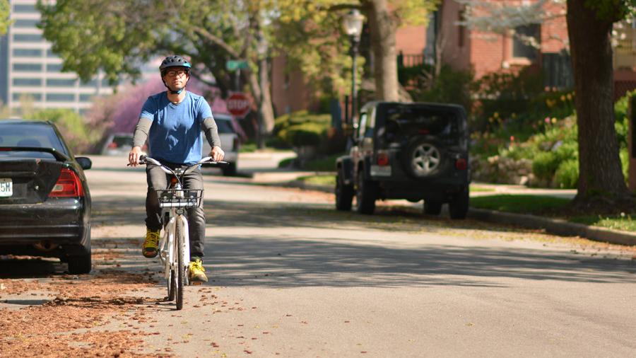 Man riding a bike down a city street