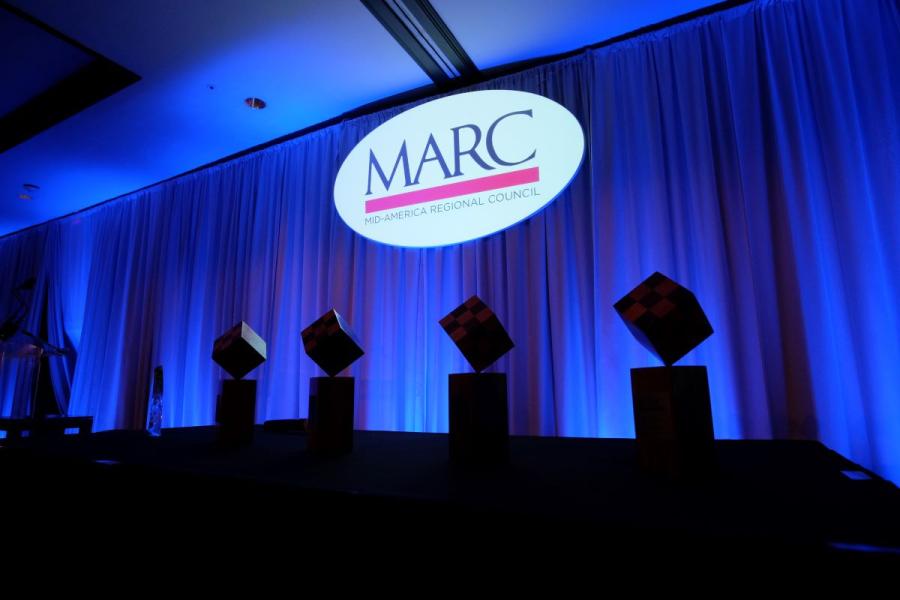 MARC logo projected on screen with awards in shadow foreground