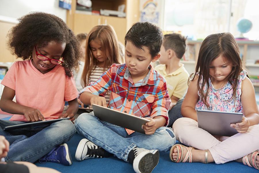 Three children looking at tablet computers