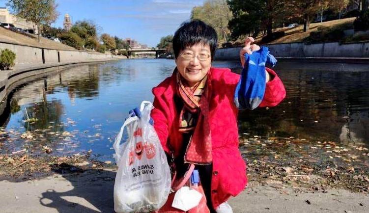 volunteer holds up pair of discarded socks found along streamside trail