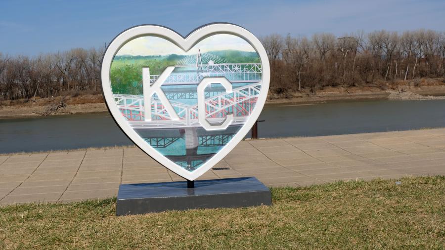 A Parade of Hearts sculpture sits near a sidewalk. 