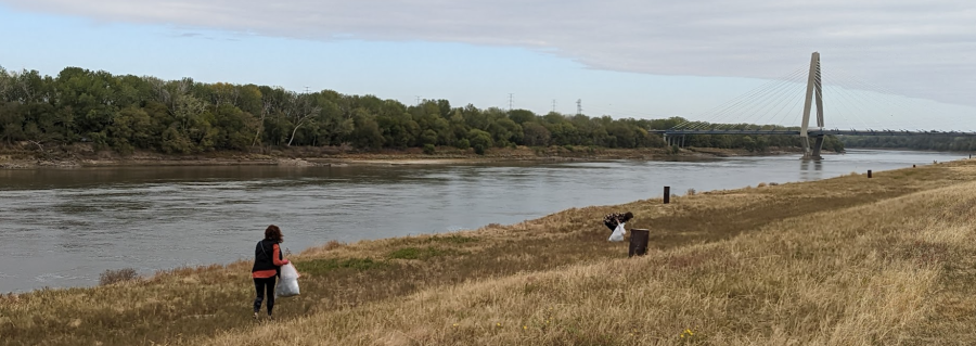 Two people pick up litter along the Berkley Riverfront Trail in downtown Kansas City