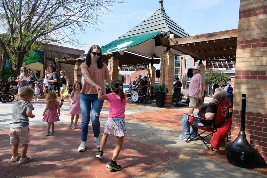 Family dancing outdoors at the Overland Park Farmer's Market