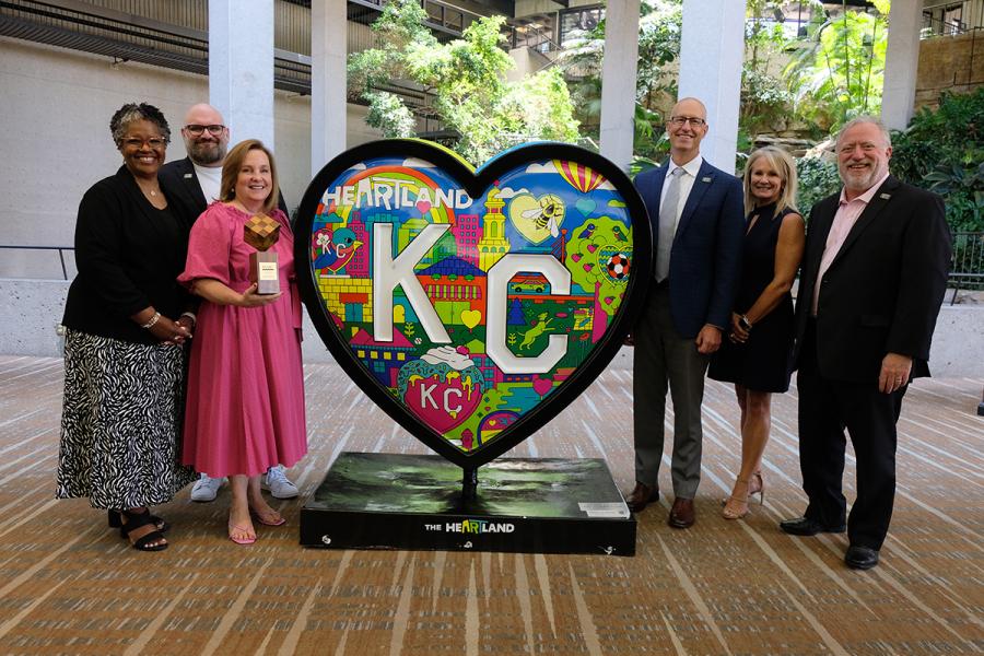 Parade of Hearts Board in front of a heart with their award